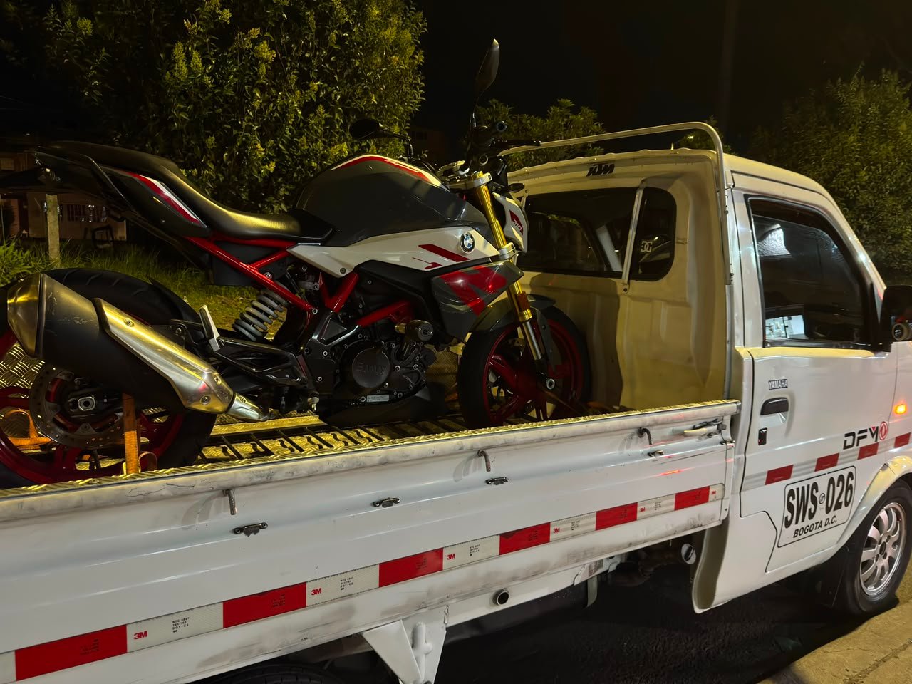 Servicio de grúa para motos de noche con varias motocicletas en Bogotá